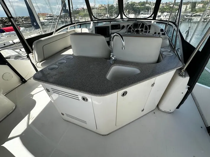  Yacht Photos Pics 2006 Silverton 43 Sport Bridge yacht interior with helm and kitchenette.