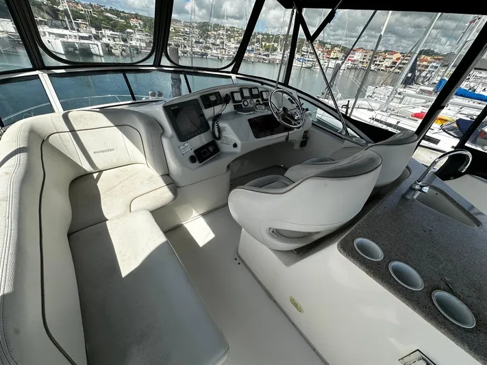  Yacht Photos Pics 2006 Silverton 43 Sport Bridge yacht interior with helm, seating, and marina view.