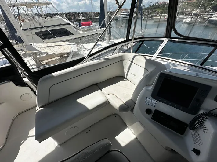  Yacht Photos Pics 2006 Silverton 43 Sport Bridge interior with seating and navigation console, docked at marina.