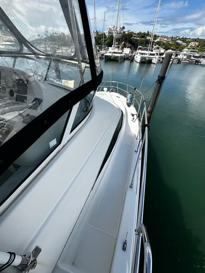  Yacht Photos Pics 2006 Silverton 43 Sport Bridge yacht docked in a marina, showcasing sleek design and clear waters.