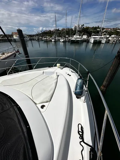  Yacht Photos Pics 2006 Silverton 43 Sport Bridge yacht docked in a marina, surrounded by calm waters and sailboats.