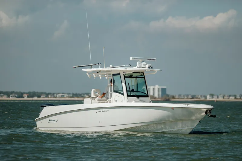  Yacht Photos Pics 2013 Boston Whaler 320 Outrage boat cruising on open water under a cloudy sky.