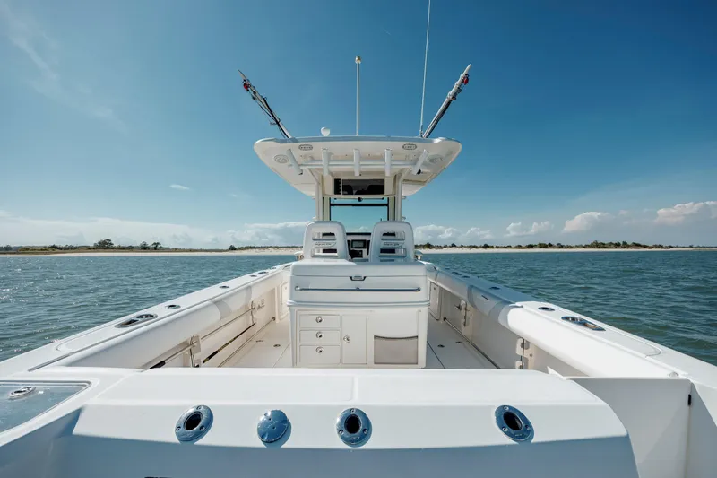  Yacht Photos Pics 2013 Boston Whaler 320 Outrage boat on water, clear sky, fishing rods visible.