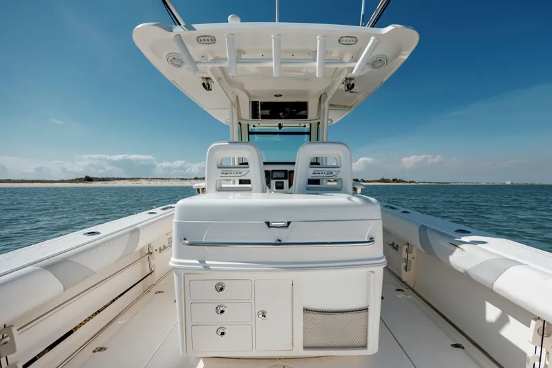  Yacht Photos Pics 2013 Boston Whaler 320 Outrage boat interior with seating and storage, on calm water.