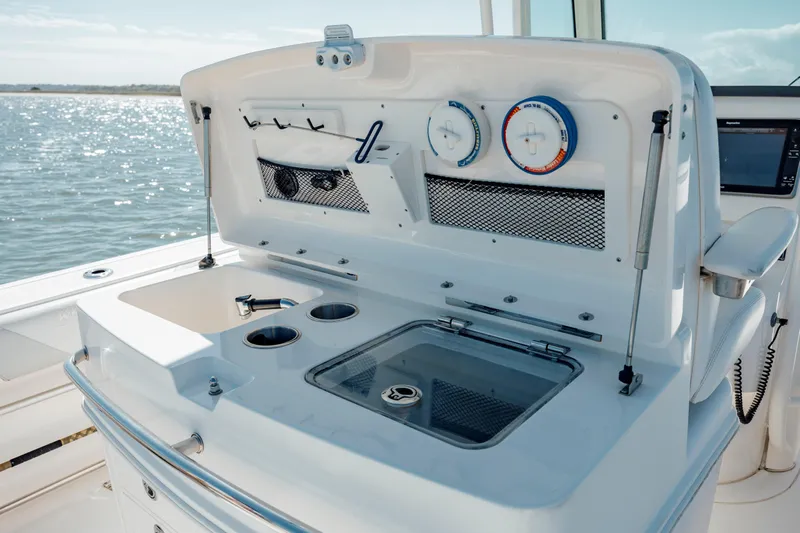  Yacht Photos Pics 2013 Boston Whaler 320 Outrage boat console with gauges and storage, on a sunny day at sea.