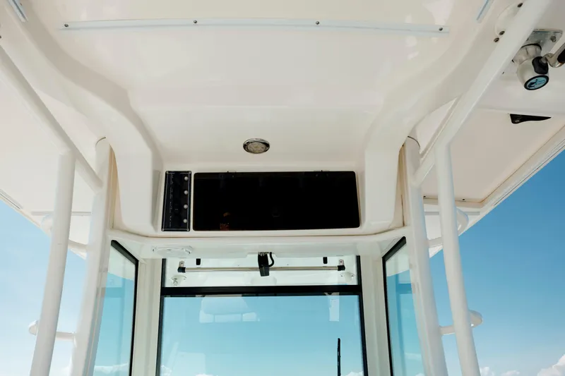  Yacht Photos Pics 2013 Boston Whaler 320 Outrage interior view with overhead console and clear sky.