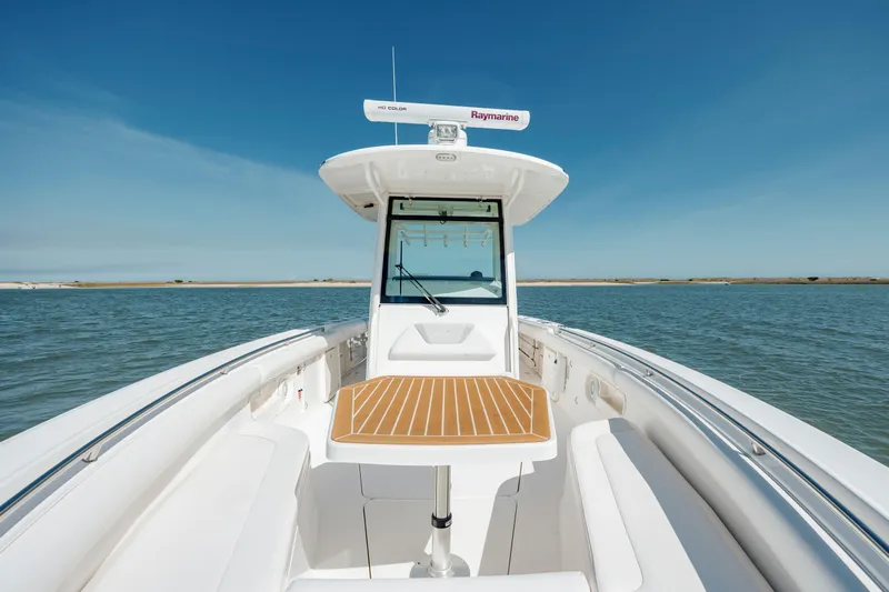  Yacht Photos Pics 2013 Boston Whaler 320 Outrage boat on calm water, featuring sleek design and spacious deck.