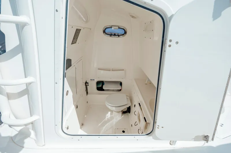 Yacht Photos Pics 2013 Boston Whaler 320 Outrage boat interior with compact marine toilet and storage.