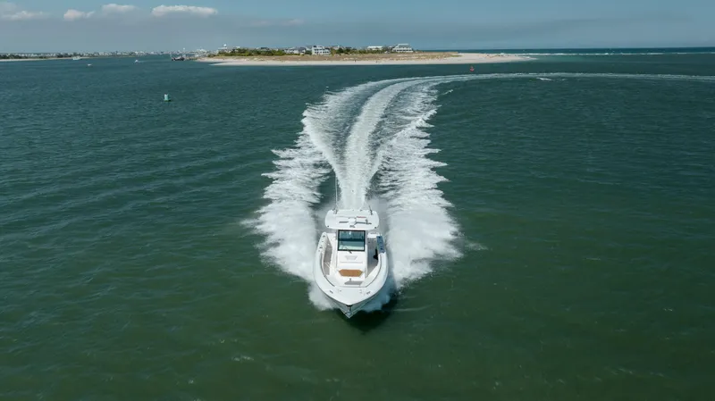  Yacht Photos Pics 2013 Boston Whaler 320 Outrage cruising on open water, leaving a wake behind.