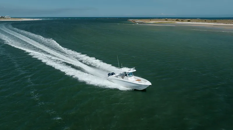  Yacht Photos Pics Boston Whaler 320 Outrage 2013 cruising on open water, leaving a wake behind.