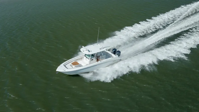  Yacht Photos Pics 2013 Boston Whaler 320 Outrage speeding on open water, aerial view.