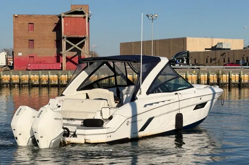  Yacht Photos Pics 2021 Cruisers Yachts 338 Outboard boat on water near industrial buildings.