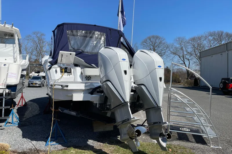  Yacht Photos Pics 2021 Cruisers Yachts 338 Outboard with dual engines, parked outdoors.