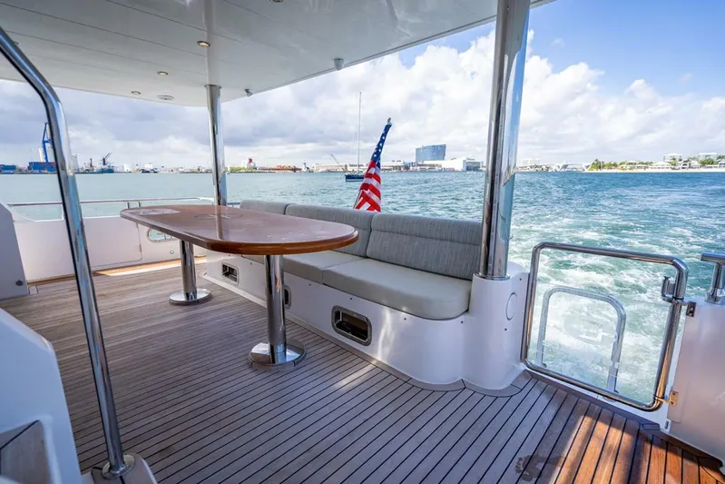 Sunny Seajay Yacht Photos Pics Luxurious 2022 Hampton 658l Endurance yacht deck with seating, table, and ocean view.