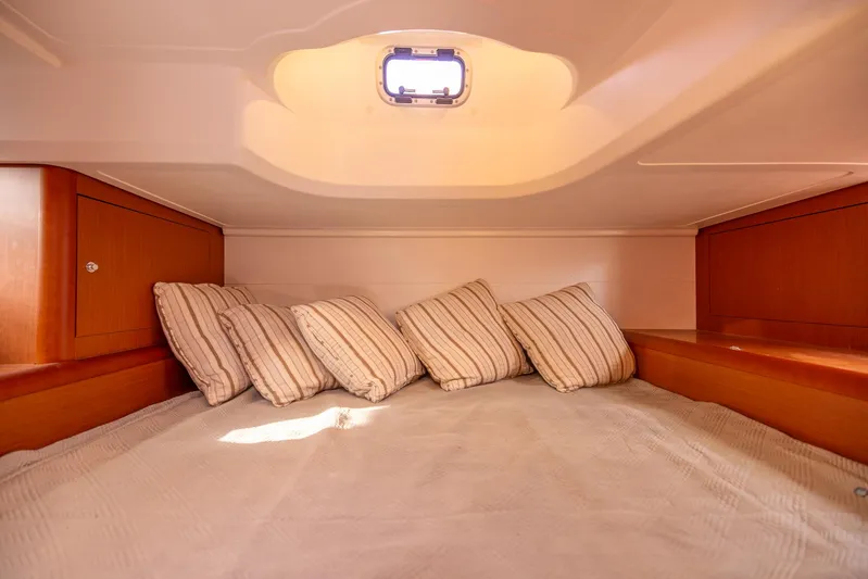 Ms Bordeaux Yacht Photos Pics Cozy cabin interior of 2013 Beneteau Gran Turismo 38 with striped pillows and wooden accents.