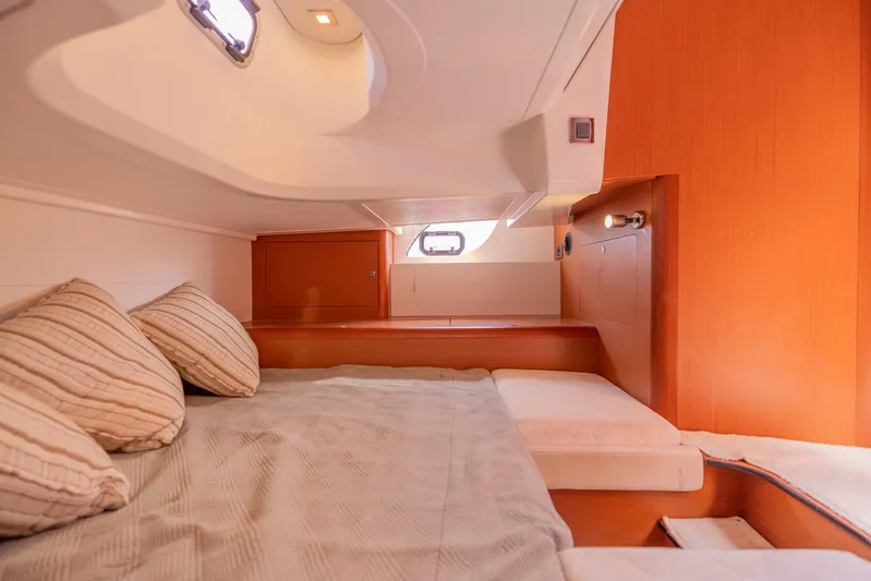 Ms Bordeaux Yacht Photos Pics Interior cabin of 2013 Beneteau Gran Turismo 38 yacht, featuring cozy bedding and wooden accents.