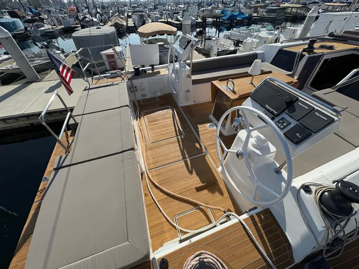 560 Exclusive Yacht Photos Pics Dufour 560 Exclusive 2018 yacht cockpit with steering wheel and seating, docked at marina.