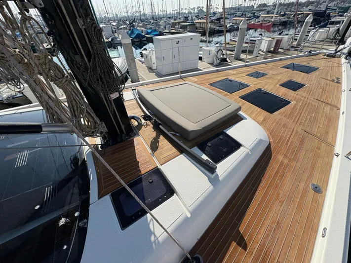 560 Exclusive Yacht Photos Pics 2018 Dufour 560 Exclusive yacht deck with teak flooring and sunbathing area in marina.