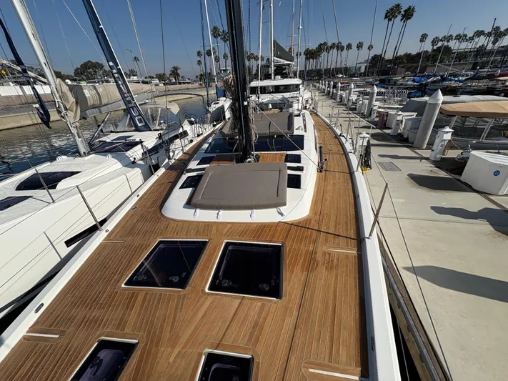 560 Exclusive Yacht Photos Pics Dufour 560 Exclusive 2018 yacht with teak deck, docked at marina under clear sky.