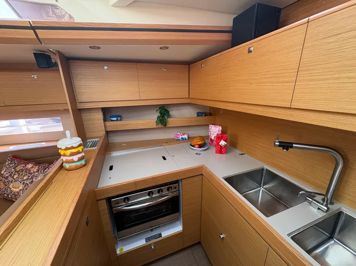 560 Exclusive Yacht Photos Pics Modern kitchen interior of 2018 Dufour 560 Exclusive yacht with wooden cabinetry and stainless steel sink.