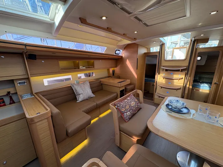 560 Exclusive Yacht Photos Pics Luxurious interior of 2018 Dufour 560 Exclusive yacht with elegant wood finish and cozy seating.