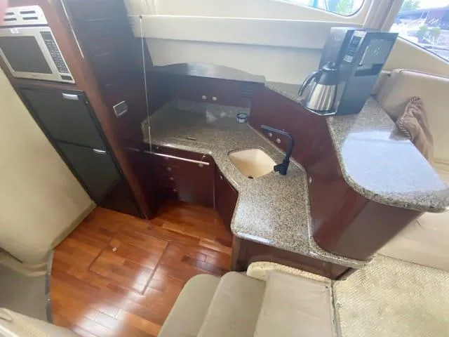  Yacht Photos Pics Interior of 2006 Sea Ray 44 Sedan Bridge with kitchen and wood flooring.