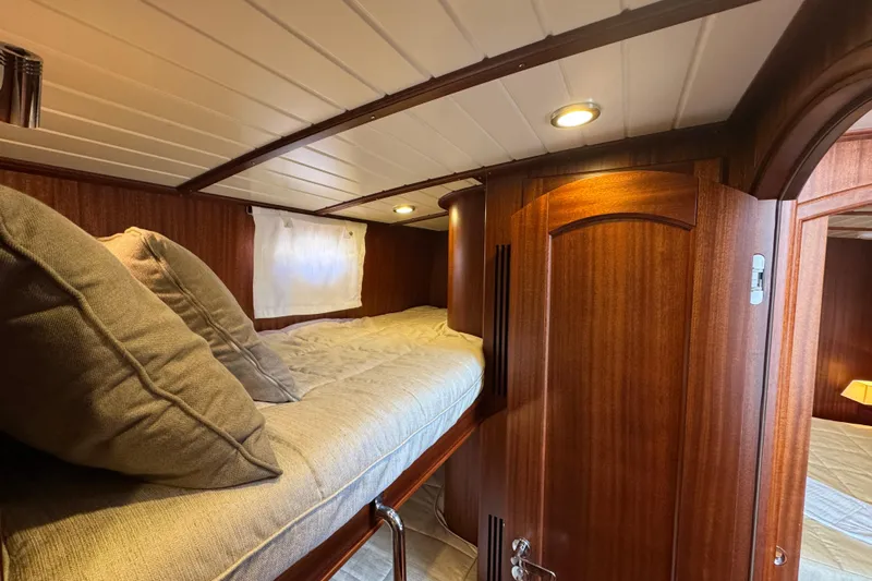  Yacht Photos Pics Cozy cabin interior of 2020 Vicem 50 Classic yacht with wooden finish and soft bedding.