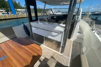 2021 Nimbus T11 boat interior with seating, table, and helm at marina.