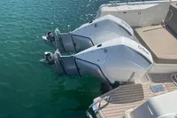 Twin outboard motors on a 2021 Nimbus T11 boat, docked on calm water.