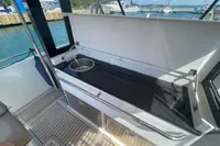 Nimbus T11 2021 boat interior with open storage and sink, docked at marina.