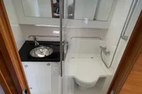 Compact bathroom in 2021 Nimbus T11 boat with shower, sink, and toilet.