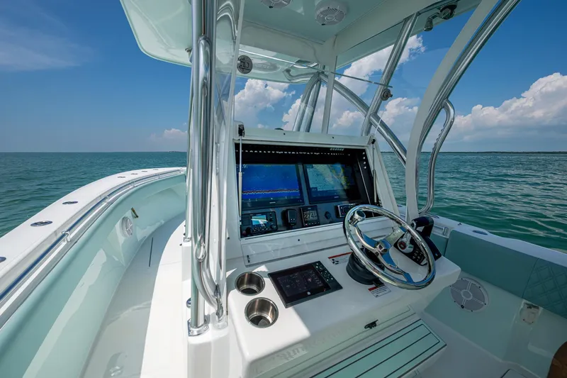  Yacht Photos Pics 2023 SeaHunter 31 Tournament boat helm with navigation screens, steering wheel, and ocean view.