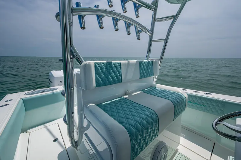  Yacht Photos Pics 2023 SeaHunter 31 Tournament boat interior with teal and white seating, ocean backdrop.