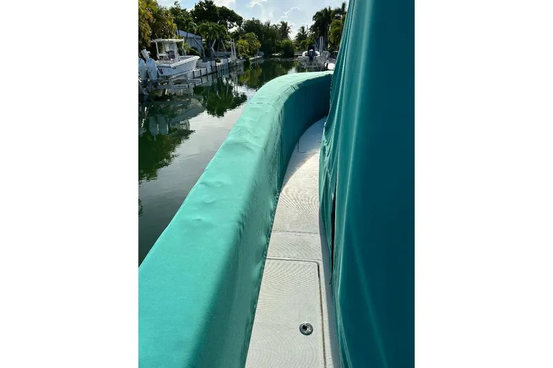  Yacht Photos Pics 2023 SeaHunter 31 Tournament boat with teal cover, docked by a canal.