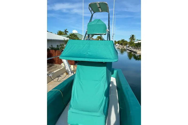  Yacht Photos Pics 2023 SeaHunter 31 Tournament boat with teal covers, docked by a canal.