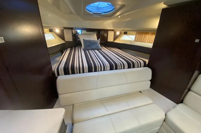  Yacht Photos Pics 2017 Monterey 355 Sport Yacht interior with striped bedding and modern furnishings.