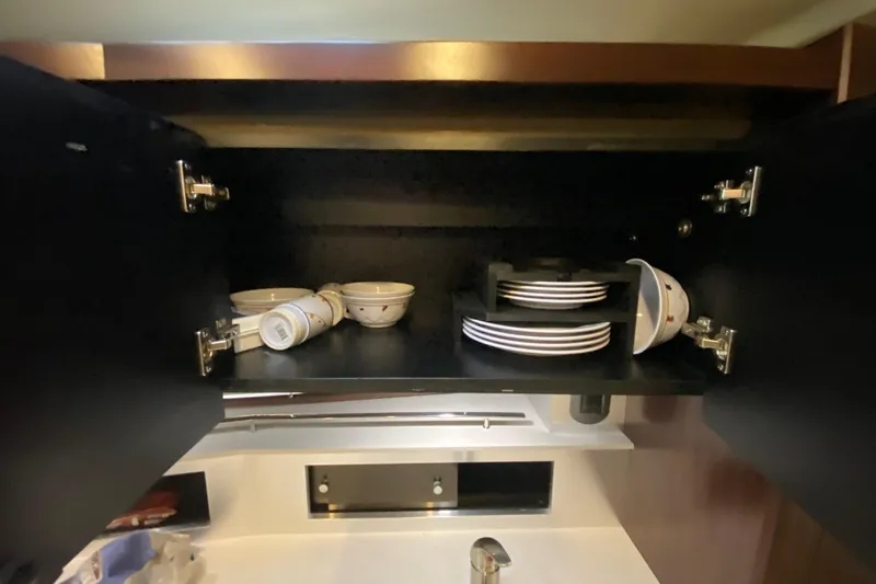  Yacht Photos Pics Open cabinet with dishes inside a 2017 Monterey 355 Sport Yacht kitchen.