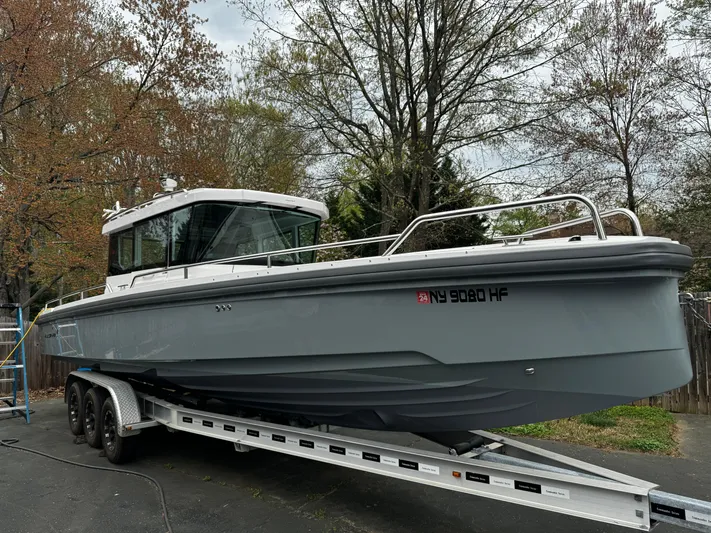  Yacht Photos Pics 2019 Axopar 28 CABIN boat on trailer, parked outdoors.