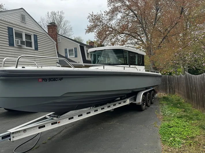  Yacht Photos Pics 2019 Axopar 28 CABIN boat on trailer in residential driveway.