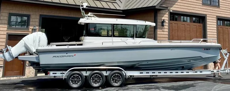  Yacht Photos Pics 2019 Axopar 28 CABIN boat on trailer, parked outside a garage.