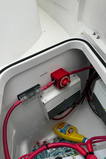  Yacht Photos Pics 2019 Axopar 28 CABIN battery compartment with red cables and cleaning supplies.