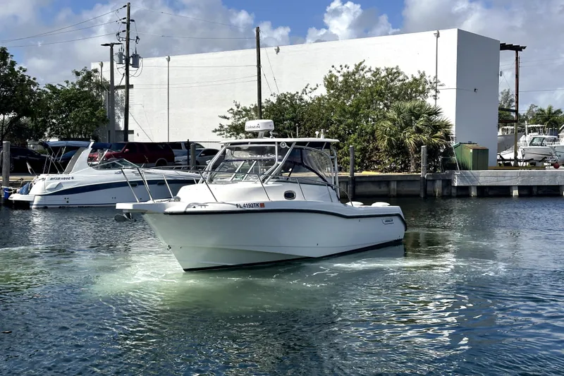  Yacht Photos Pics 2006 Boston Whaler 285 Conquest boat on water near dock, clear sky background.