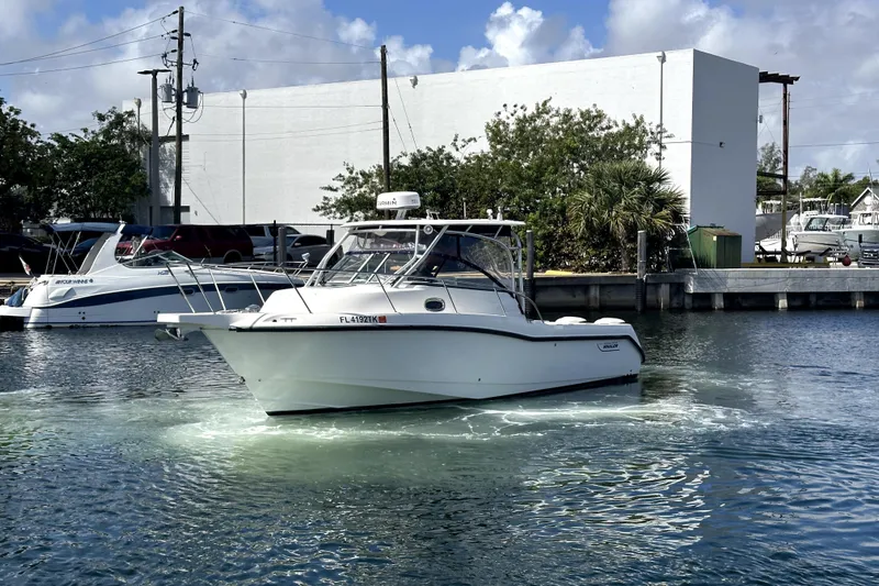  Yacht Photos Pics 2006 Boston Whaler 285 Conquest boat on water near marina, clear sky background.