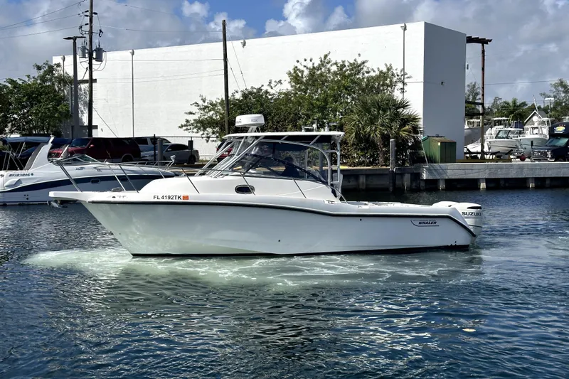  Yacht Photos Pics 2006 Boston Whaler 285 Conquest boat on water near marina, clear sky background.