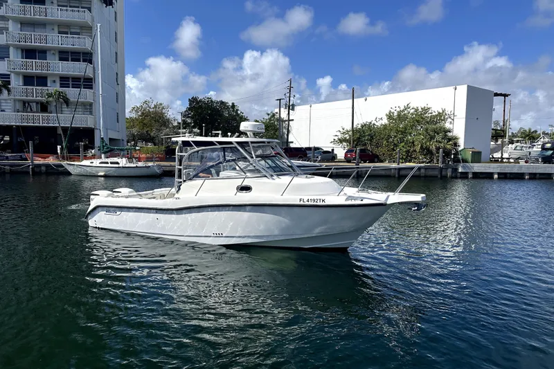  Yacht Photos Pics 2006 Boston Whaler 285 Conquest boat docked in a marina under a clear blue sky.