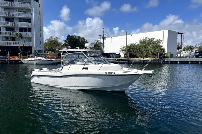  Yacht Photos Pics 2006 Boston Whaler 285 Conquest boat docked in a marina under a clear blue sky.