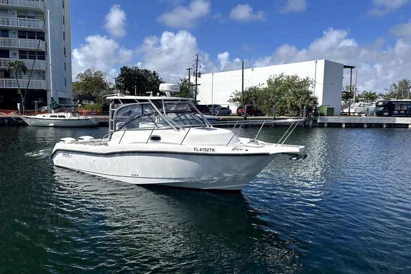  Yacht Photos Pics 2006 Boston Whaler 285 Conquest boat docked in a marina under a clear sky.