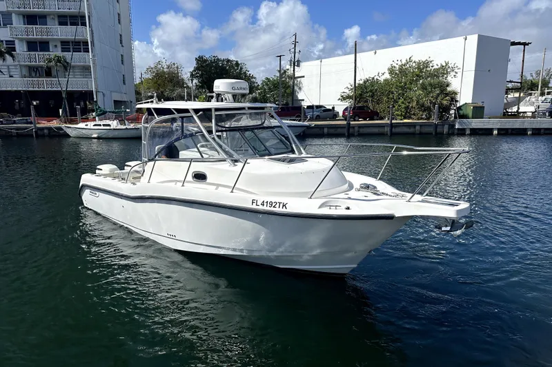  Yacht Photos Pics 2006 Boston Whaler 285 Conquest boat docked in a marina under a clear blue sky.