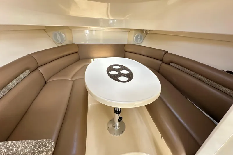  Yacht Photos Pics 2006 Boston Whaler 285 Conquest cabin interior with brown seating and round table.