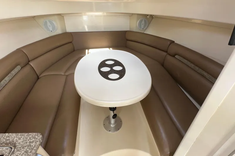  Yacht Photos Pics 2006 Boston Whaler 285 Conquest cabin interior with brown seating and white table.